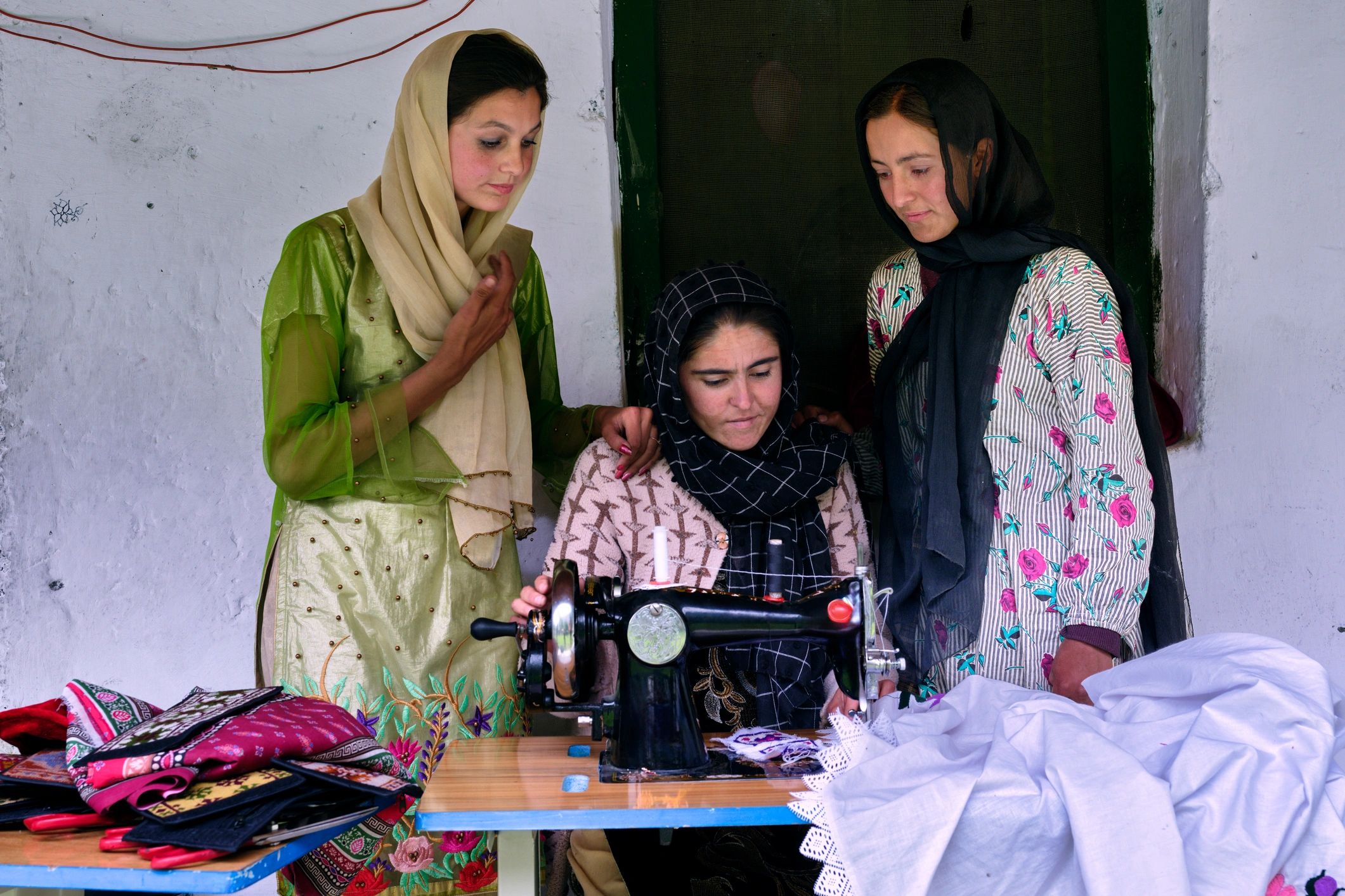 Embroidery artisans collaborating in a textile workshop